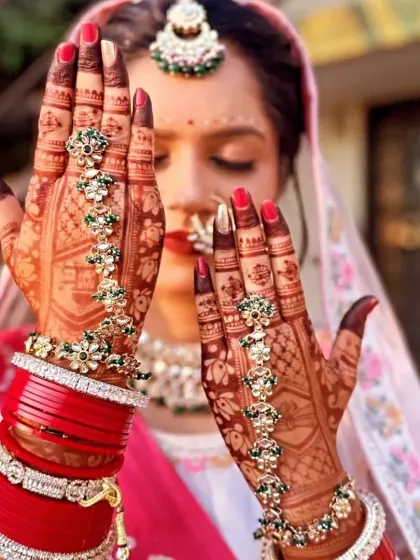 A stunning bride showcasing her mehndi, perfectly accessorized with traditional jewelry. The deep color of the henna complements her red bangles beautifully.