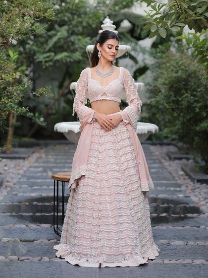 A full view of this stunning pastel look. The ruffled lehenga paired with soft, modern makeup creates a chic and sophisticated statement.