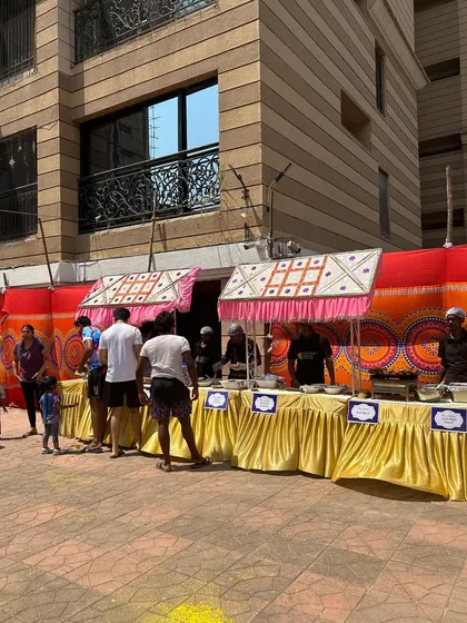 A full view of my food stall setup for a large society Holi party. The colorful backdrop and festive canopies create the perfect atmosphere for a day of fun and food.