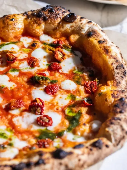 A close-up of my Sundried Tomato & Basil Pizza. The sweetness of the tomatoes and the fresh, herbaceous notes of the basil pesto create a vibrant and flavorful combination that feels like sunshine on a plate.