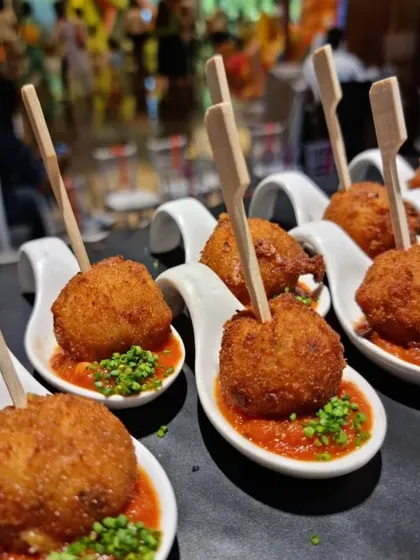 Mini risotto balls, or arancini, served on tasting spoons. A gourmet yet kid-friendly bite that's easy for little hands to manage.