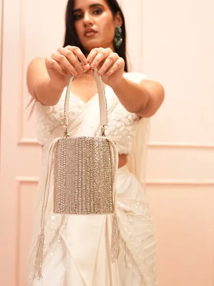 This is one of my signature handcrafted potli bags, perfect for any wedding or festive occasion. I love how the structured bucket shape is covered in shimmering diamond studs, creating a look of affordable luxury.