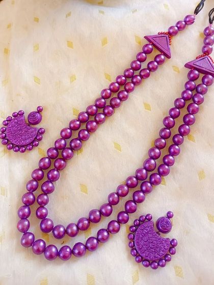 A beautiful two-layer 'maharani' style necklace in a rich purple. The set is made entirely of terracotta beads and comes with matching chandbali-style earrings.