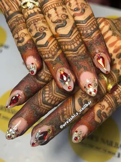 This is where art meets tradition. I designed this custom bridal set with ruby-red and silver gems to perfectly complement the beautiful, deep tones of the mehendi. It's all about creating a look that feels both royal and personal for your special day.