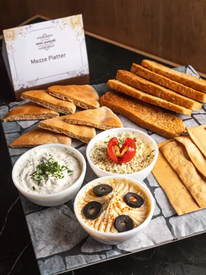 Our culinary range extends far beyond India. This fresh Mezze Platter, with creamy hummus, flavourful dips, and warm pita, is a perfect example of the authentic global cuisines we offer.