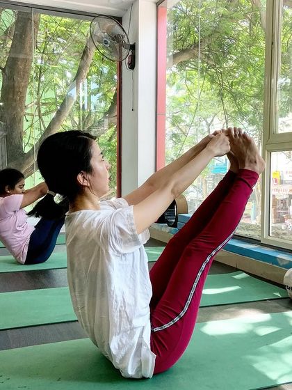 A student practices a seated pose, finding a moment of peace in our sunlit studio.
