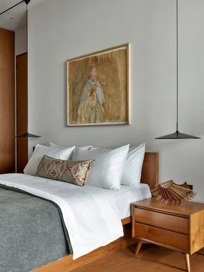 This bedroom is designed with a simple, understated aesthetic defined by warm wooden accents. The material palette, from the flooring to the custom furniture, ties into the warmth of the rest of the home, creating a cohesive and calming environment.