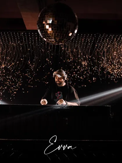 A wide shot of my setup at EVVA, framed by spotlights. A professional setup and stage presence are crucial for commanding a large club environment.