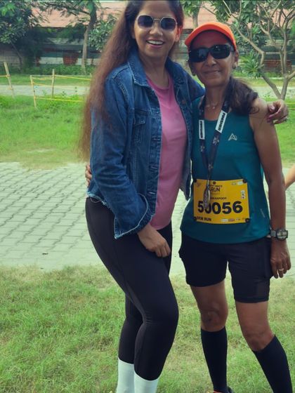 A team member posing with a participant, showcasing the friendly and supportive atmosphere of our running events.