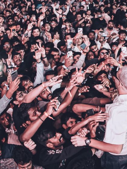DJ Snake gets up close and personal, surrounded by a massive crowd of fans all trying to get a photo.