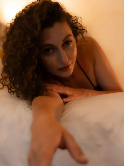 An inviting and intimate portrait that plays with depth of field. The focus on her eyes creates a powerful connection, inviting the viewer into her space.
