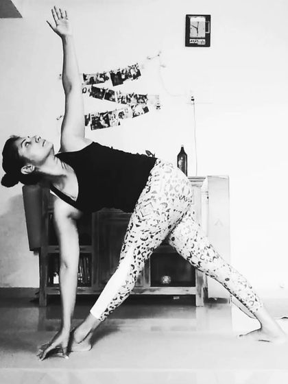 Holding Trikonasana, or Triangle Pose, at home. This is a reminder to be the hero of your own story and to let your own light shine.