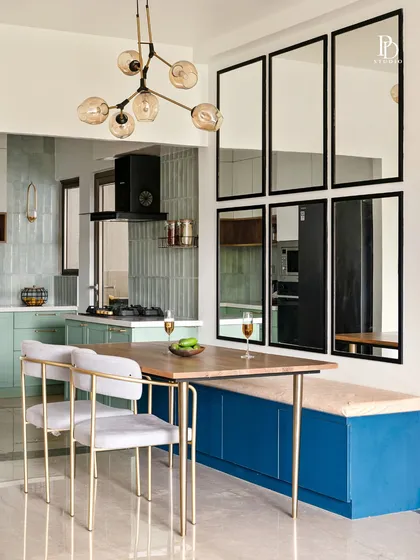 In this open-plan home, we designed a dining area that is both vibrant and practical. The custom blue bench with built-in storage and a wall of mirrors makes the space feel larger, brighter, and full of personality.