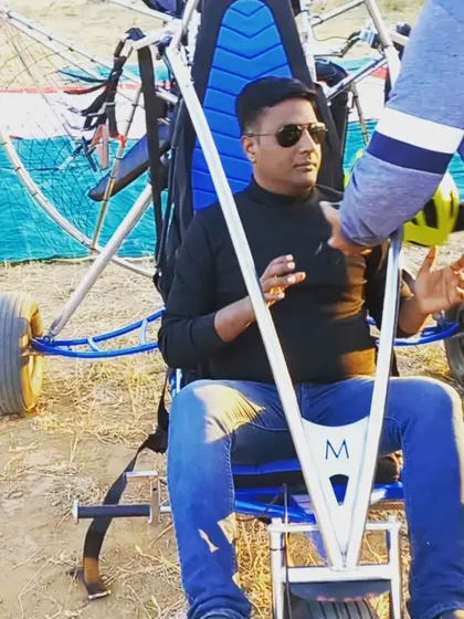 Getting briefed and strapped in before a paramotor flight. Our ground crew and pilots ensure you are comfortable and fully prepared for your adventure, explaining every step of the process.