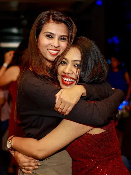 Friends hugging and sharing a happy moment at the Christmas party.