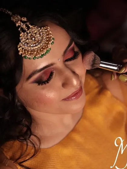 The process of creating a flawless base. Here, I am applying blush to add a natural flush of color to the cheeks for Chinmayi's mehendi look.