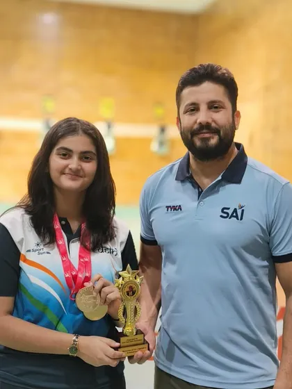 With a student showcasing her gold medal and trophy. We train for results, and our students consistently deliver.