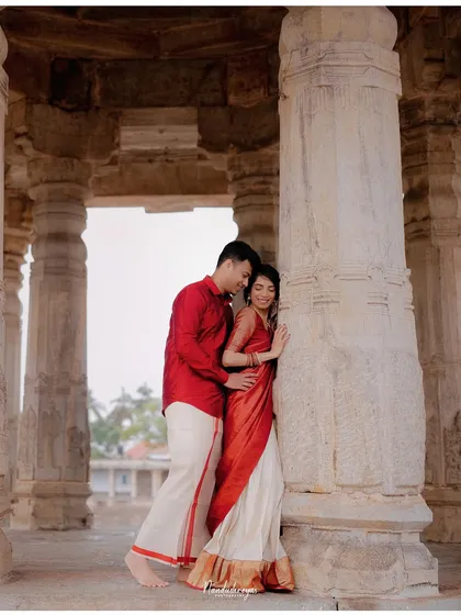 A romantic pose with the couple leaning against a temple pillar, the soft light enhancing the mood.