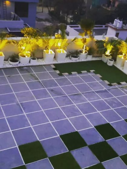 A wider view of the illuminated planters, showing how they can transform a large, plain tiled terrace into a sophisticated space.