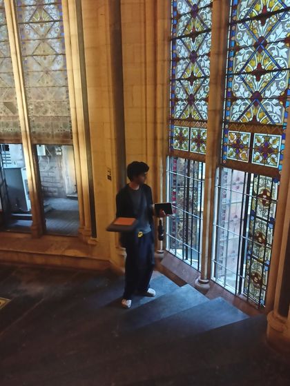 A photo of me sketching inside a beautiful old building. I find inspiration everywhere, from grand architecture to small details.