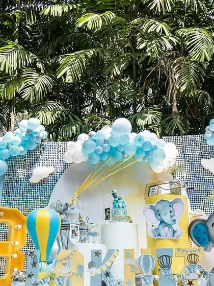 Another view of the baby elephant party, showcasing the full backdrop with balloon clouds and cute elephant illustrations.