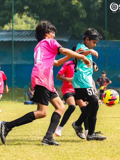 A GSC player dribbles past a Manav Rachna opponent, showcasing quick feet and agility.