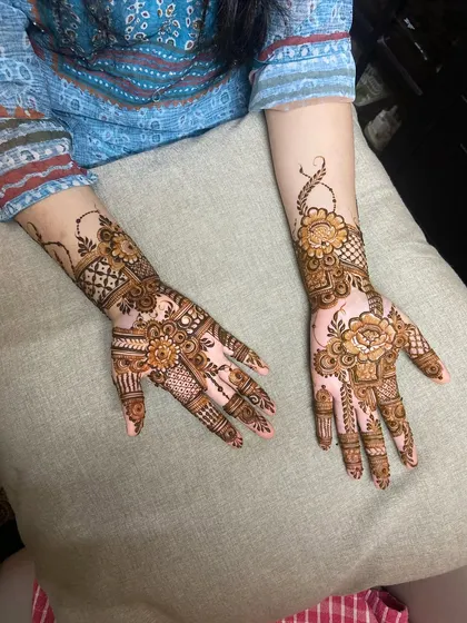 A fusion design that combines bold Arabic flowers on the palm with geometric Indian patterns on the wrist and fingers.
