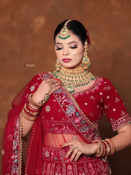 A beautiful bridal portrait featuring a classic red lehenga with green jewelry. I used a soft glam eye and a bold lip to create a balanced and striking look.