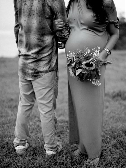 A classic black and white shot from behind, showing the couple walking arm-in-arm. The focus on her holding the bouquet and his arm around her is beautifully symbolic.