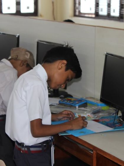A student carefully works on his drawing during the 2023 Olympiad at St. Clare’s School Unit II.