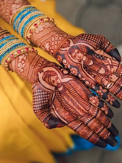 A close-up of a stunning bride and groom portrait design on the palms, beautifully accessorized with bridal bangles. The detail and shading are exquisite.
