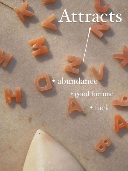 Each initial is carved from Peach Moonstone, a stone known to attract abundance, good fortune, and luck in love. Your chosen letter becomes a vessel for this positive energy.