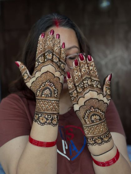 A happy client showing off her festive Karwachauth mehendi.