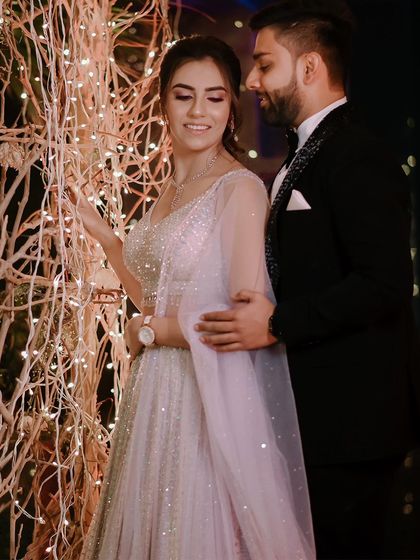 A romantic portrait of the couple against a backdrop of twinkling lights.