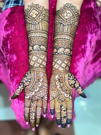 This design features the couple's initials and wedding rings near the elbows, with the rest of the arms covered in a beautiful floral and geometric pattern.