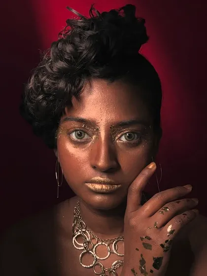 Another angle of the editorial look, showing the messy, artistic application of gold on the hands and face.