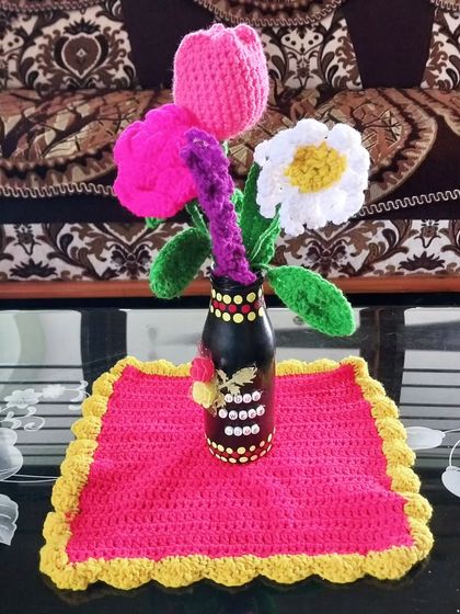 A beautiful home decor setup showing my crochet flowers in a vase on a crochet table mat.