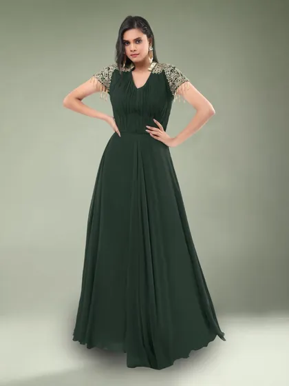 This simple yet elegant dark green gown features beautiful embellished sleeves. It's a sophisticated choice for a formal dinner or event.