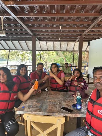 The group enjoying some drinks and snacks after a water activity, all wearing their life jackets.