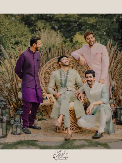 Dapper groomsmen styled for a daytime wedding event. We selected outfits in a range of complementary colors like sage green, purple, and pink, creating a look that is coordinated yet allows for individual personality.