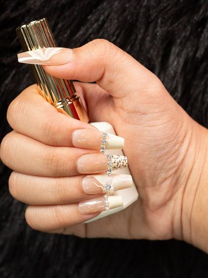 A highly detailed and luxurious nail design. This set features a neutral base with intricate 3D textures and carefully placed rhinestones, demonstrating our expertise in creating high-fashion, couture nail art.