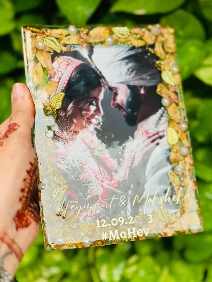 The couple's wedding hashtag, #MoHey, is engraved along with their names and date, adding another layer of personal storytelling to this varmala preservation frame.