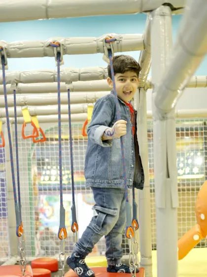 This young adventurer tackles one of our rope-based obstacles with a huge smile.