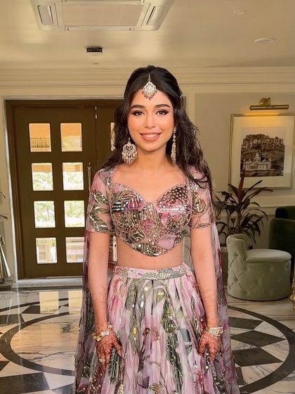 A happy bride showing off her whimsical butterfly braid hairstyle, a perfect choice for a fun and youthful Mehendi look.