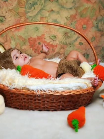 This client photo showcases a full harvest-themed setup. The baby is wearing my brown bunny outfit, surrounded by crochet carrots and pumpkins I made as photoshoot props.