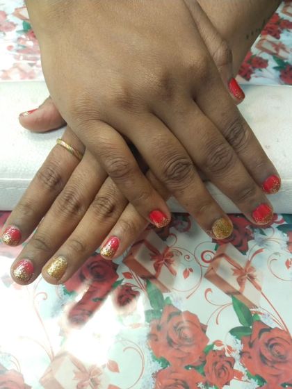 A festive and fun combination of red and gold glitter gel polish on short nails. This is a simple but very impactful look, perfect for celebrations like weddings or holidays.