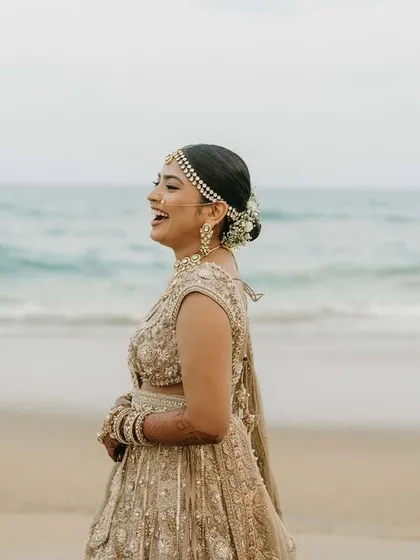 A candid laugh on the beach. Her natural makeup and secure hairstyle hold up perfectly against the sea breeze.