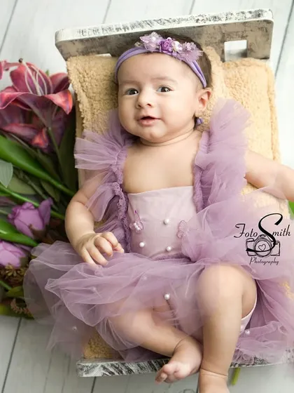 A calm and observant moment. This little one is taking in her surroundings from her cozy bed, looking like a little princess.