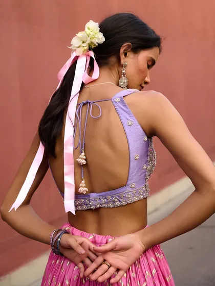 The back of this lavender and pink lehenga from the Anam Cara collection is a work of art. The delicate blouse ties and ribbon in the hair add a touch of playful romance.