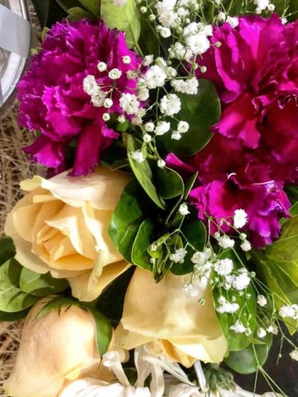 A close-up of a beautiful floral arrangement of magenta carnations and cream roses. Fresh flowers are a key element I use to elevate the ambiance of any event.